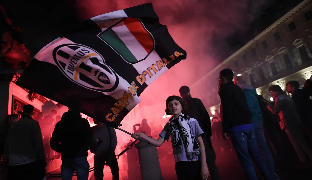 Seorang anak merayakan tim kesayangannya Juventus meraih juara Liga Serie A Italia di Turin (13/5). Ini merupakan gelar ketujuh beruntun Juventus. (AFP Photo/Marco Bertorello)
