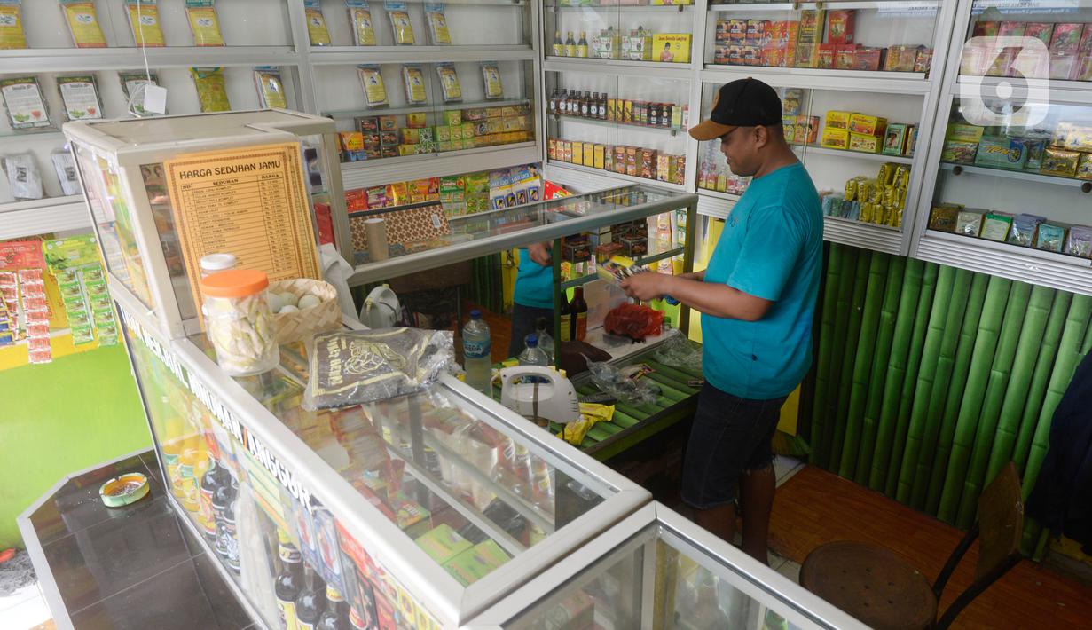 Hendri (37) penjual jamu aduk sedang merapikan daganganya sambil menunggu pembeli di kawasan Pamulang, Tangerang Selatan, Banten, Senin (28/9/2020). (merdeka.com/Dwi Narwoko)