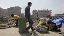 Warga mencari barang yang masih bisa terpakai di tempat pengungsian korban gempa bumi di Chuchepati, Kathmandu, Nepal, Selasa (14/3). Pemerintah Nepal terpaksa menggusur kamp ini karena dianggap sudah terlalu lama. (AP Photo)