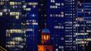 Lampu menyala pada beberapa gedung bank di Frankfurt, Jerman, Kamis (24/9/2020). Di latar depan gereja Paul. (AP Photo/Michael Probst)