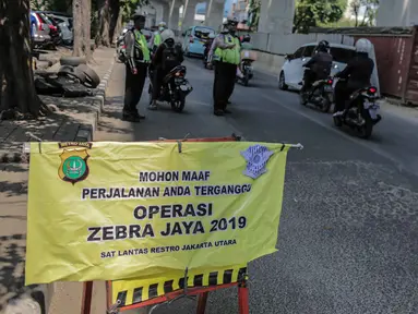 Polisi lalu lintas menggelar Operasi Zebra 2019 di Jalan Boulevard Gading Raya, Jakarta, Kamis (24/10/2019). Operasi selama dua pekan hingga 5 November mendatang tersebut untuk meningkatkan kepatuhan dan kedisiplinan pengendara kendaraan bermotor dalam berlalu lintas. (Liputan6.com/Faizal Fanani)