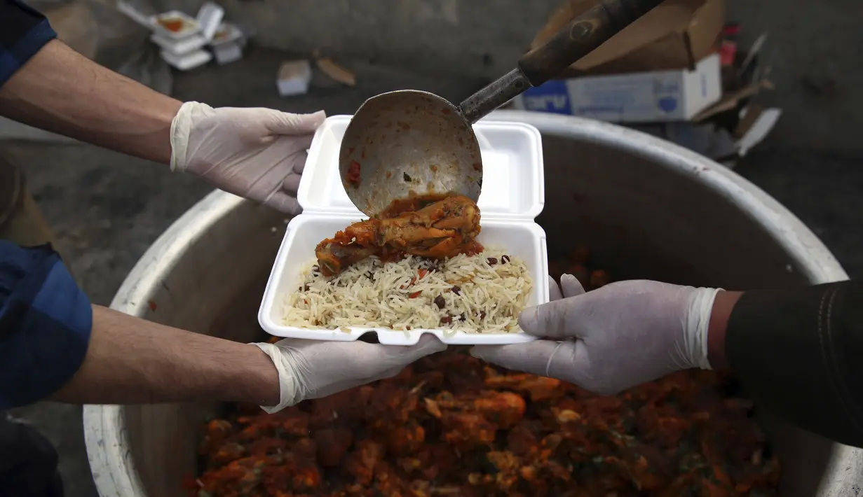 Sukarelawan menyiapkan makanan berbuka puasa gratis untuk orang-orang yang membutuhkan selama bulan puasa suci Ramadan di Kabul, Afghanistan, Kamis (7/5/2020). Muslim di seluruh dunia melewati Ramadan tahun ini di tengah pandemi virus corona COVID-19 dan PHK. (AP Photo/Rahmat Gul)