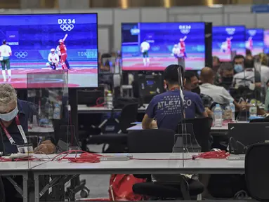 Wartawan beraktivitas di dalam Main Press Center (MPC) Olimpiade Tokyo 2020 di Tokyo pada Kamis (22/7/2021). Main Press Center mulai ramai dengan para jurnalis dari berbagai negara jelang pembukaan Olimpiade Tokyo 2020 pada 23 Juli mendatang. (Martin BERNETTI / AFP)