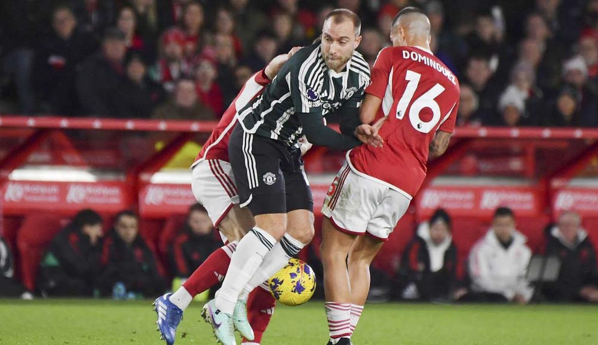 Pemain Manchester United, Christian Eriksen, diadang pemain Nottingham Forest, Nicolas Dominguez, pada laga pekan ke-20 Premier League 2023/2024, Minggu (31/12/2023) dini hari WIB. Setan Merah tak mampu berbuat banyak di markas Nottingham Forest. (AP Photo/Rui Vieira)