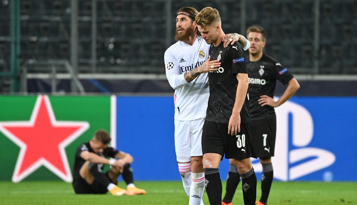 Bek Real Madrid, Sergio Ramos, bersama bek Borussia Monchengladbach, Nico Elvedi, usai pertandingan Liga Champions di Borussia Park, Rabu (28/10/2020) dini hari WIB. Real Madrid bermain imbang 2-2 lawan Borussia Monchengladbach. (AFP/Ina Fassbender)