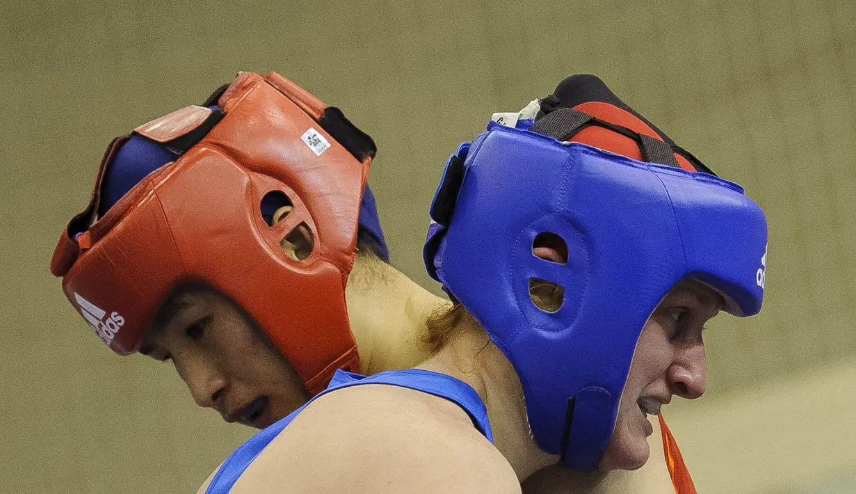 Petinju China, Li Qian, memeluk lawannya petinju Belarusia, Viktoria Kebikava (biru), pada babak kualifikasi kelas 69 kilogram Bocskai Istvan International Memorial Boxing Turnamen ke-61. (EPA/Zsolt Czegledi)