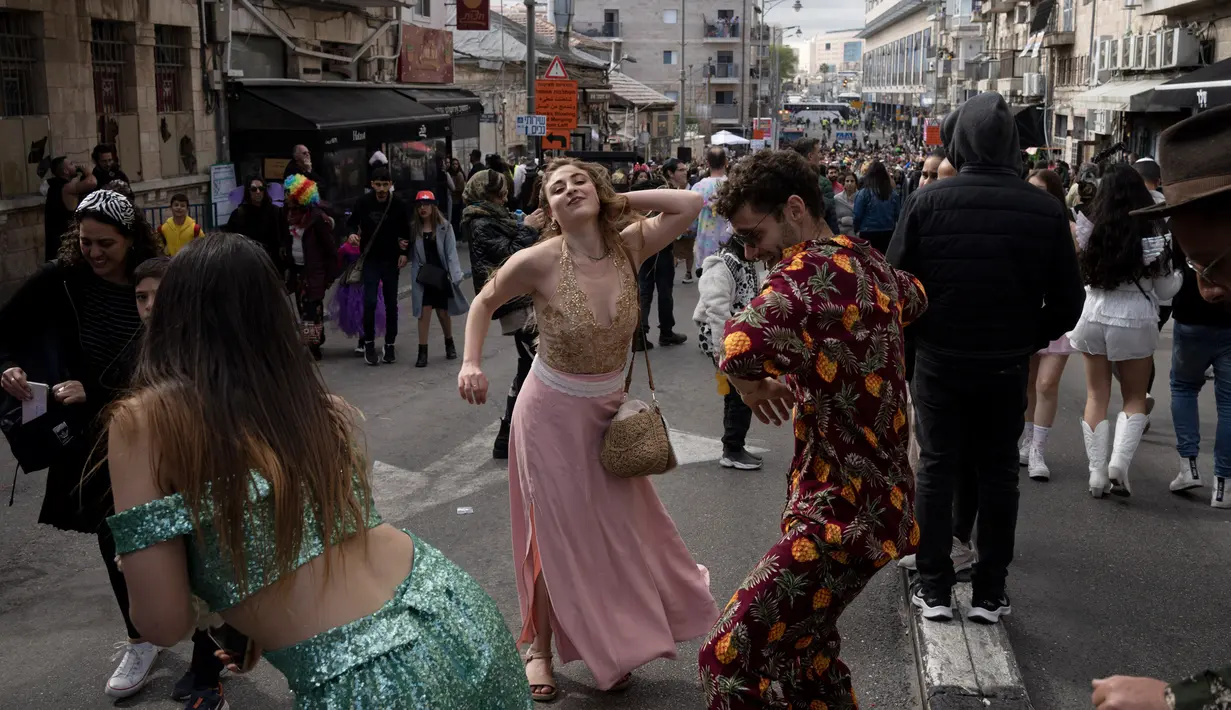 Orang Israel menari saat pesta jalanan pada Hari Raya Purim di Jalan Agrippa, Yerusalem, 8 Maret 2023. Hari Raya Purim merupakan perayaan keselamatan orang Yahudi dari genosida di Persia kuno, seperti yang diceritakan dalam Gulungan Ester. (AP Photo/Maya Alleruzzo)