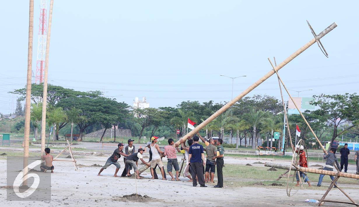 Pekerja mendirikan pohon pinang di Pantai Karnaval Ancol, Jakarta, Jumat (12/8). Taman Impian Ancol Jaya menyiapkan lomba panjat pinang kolosal dengan total pohon pinang mencapai 171 pohon. (Liputan6.com/Herman Zakharia)