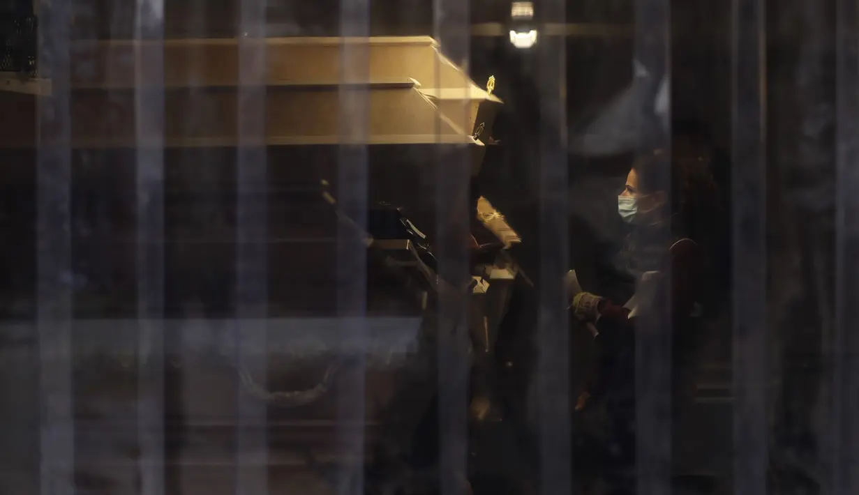 Deretan peti mati yang diletakkan di dalam peralatan pendingin melimpah di luar krematorium di Ostrava, Republik Ceko pada 7 Januari 2021. Krematorium terbesar di Republik Ceko telah kewalahan dengan meningkatnya jumlah korban pandemi virus corona Covid-19. (AP Photo/Petr David Josek)