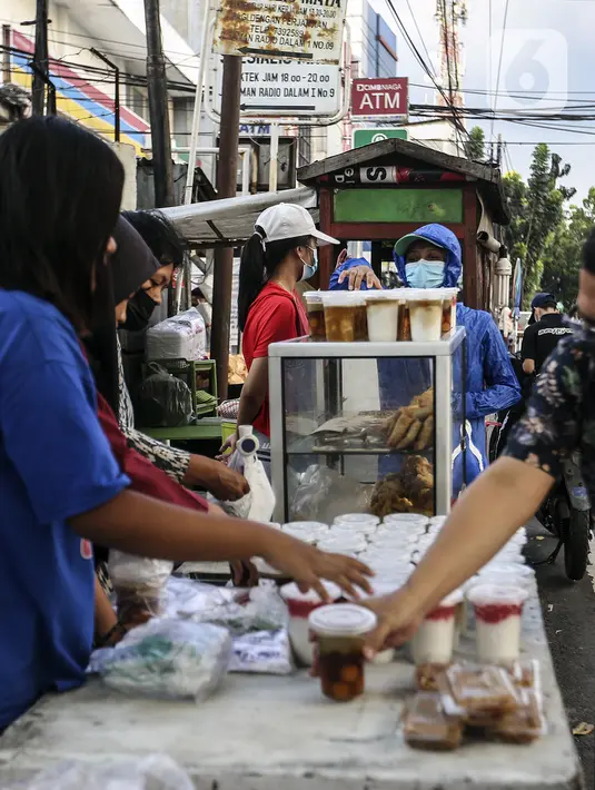 Pedagang menu berbuka puasa atau takjil melayani pembeli jelang waktu berbuka puasa di kawasan Radio Dalam, Jakarta Selatan, Senin (4/4/2022). Pedagang musiman yang menjual aneka takjil memanfaatkan momen bulan suci Ramadhan 1443 H. (Liputan6.com/Johan Tallo)