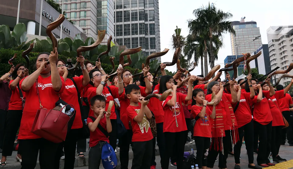 Umat Nasrani memainkan alat musik shofar saat tampil dalam acara Christmas Carol di kawasan Bunderan HI, Jakarta, Jumat (20/12/2019). Alat musik ini terbuat dari tanduk rusa Afrika, cara meniupkannnya bisa dengan nada pendek dan panjang yang memiliki makna yang berbeda. (Liputan6.com/Johan Tallo)