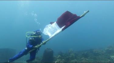 Personil Satpol Air Banyuwangi melakukan pengibaran bendera merah putih di laut Selat Bali (Istimewa)
