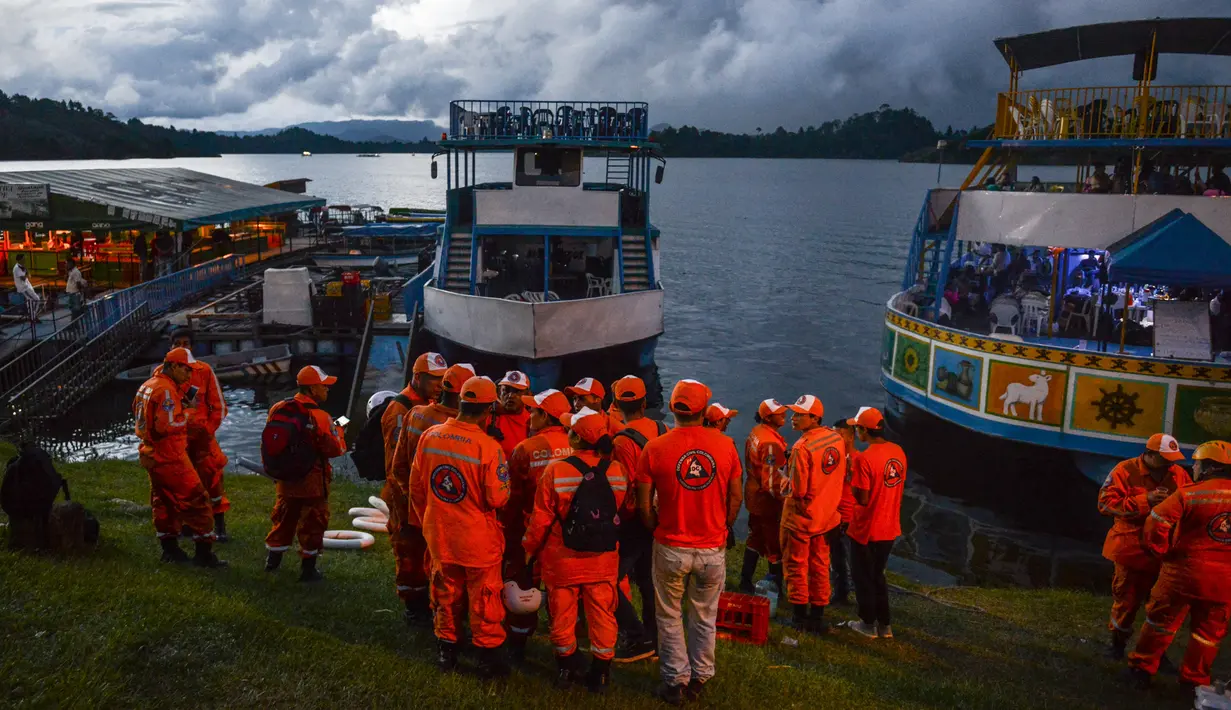 Tim penyelamat bersiap dalam operasi pencarian korban tenggelamnya kapal wisata Almirante di sebuah waduk, Kolombia barat daya, Minggu (25/6). Sejumlah helikopter militer dan penyelam juga dikerahkan ke lokasi kejadian. (JOAQUIN SARMIENTO / AFP)