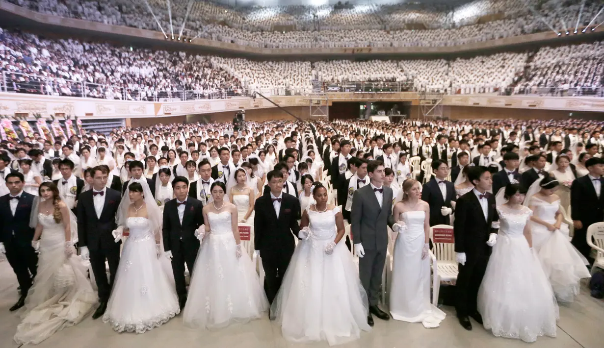 Pasangan pengantin menghadiri pernikahan massal di Cheong Shim Peace World Center, Gapyeong, Korea Selatan, Senin (27/8). Acara ini diikuti oleh pasangan pengantin dari seluruh dunia. (AP Photo/Ahn Young-joon)