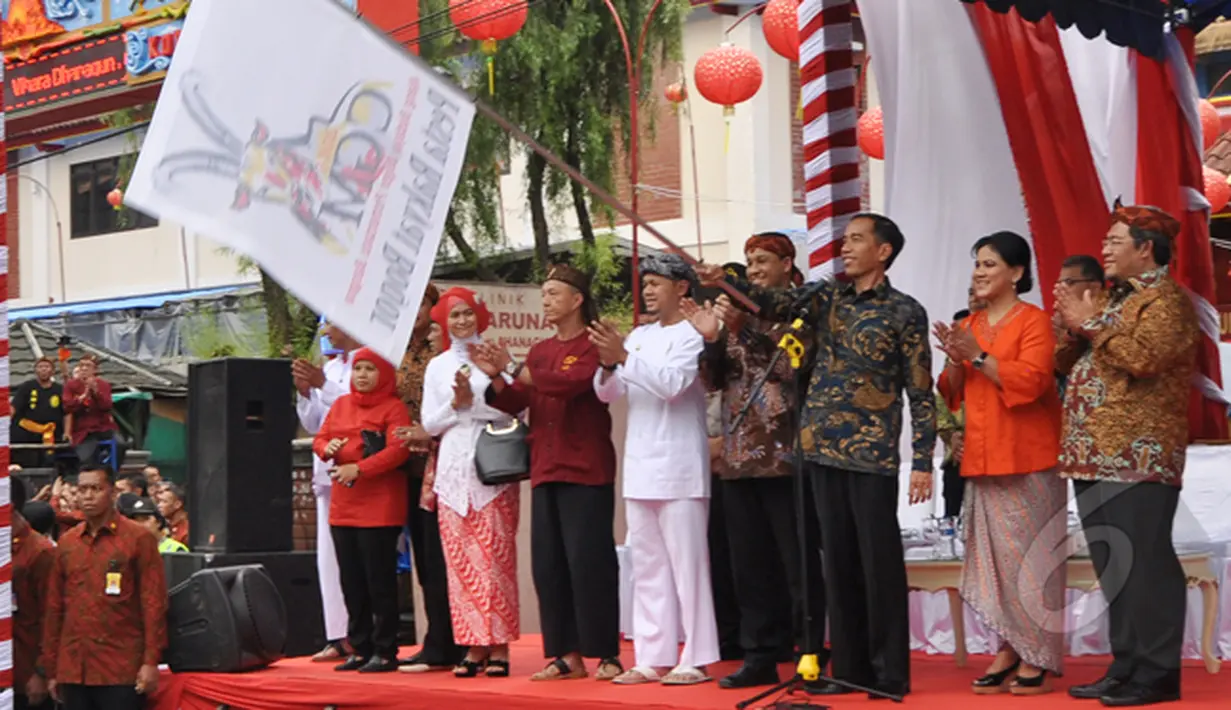 Sambil mengayunkan bendera, Presiden Jokowi memberi tanda dimulainya acara perayaan Cap Go Meh di Kota Bogor, Jawa Barat, Kamis (5/3/2015). (Liputan6.com/Faizal Fanani)