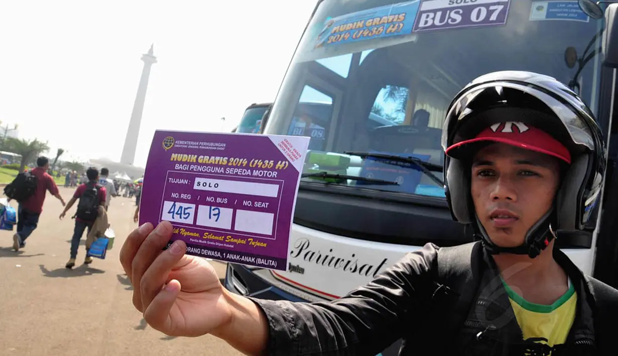 Seorang pengguna motor memperlihatkan kartu mudik gratis 2014. Jakarta, Kamis (24/7/14) (Liputan6.com/Faizal Fanani)