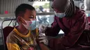 Petugas kesehatan menyuntikkan vaksin COVID-19 Sinovac kepada anak di Pospol Polsek Pamulang, Tangerang Selatan, Banten, Kamis (6/1/2022). Target vaksinasi bertujuan mendukung pembelajaran tatap muka (PTM) yang mulai dilaksanakan 100 persen pada pekan ini. (Liputan6.com/Faizal Fanani)