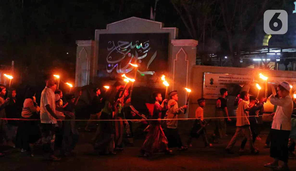 Anak-anak membawa obor sambil berkeliling kampung di kawasan Kota Tangerang, Banten, Jumat (29/7/2022) malam. Pawai obor tersebut digelar untuk menyambut malam pergantian Tahun Baru Islam atau 1 Muharam 1444 H. (Liputan6.com/Angga Yuniar)