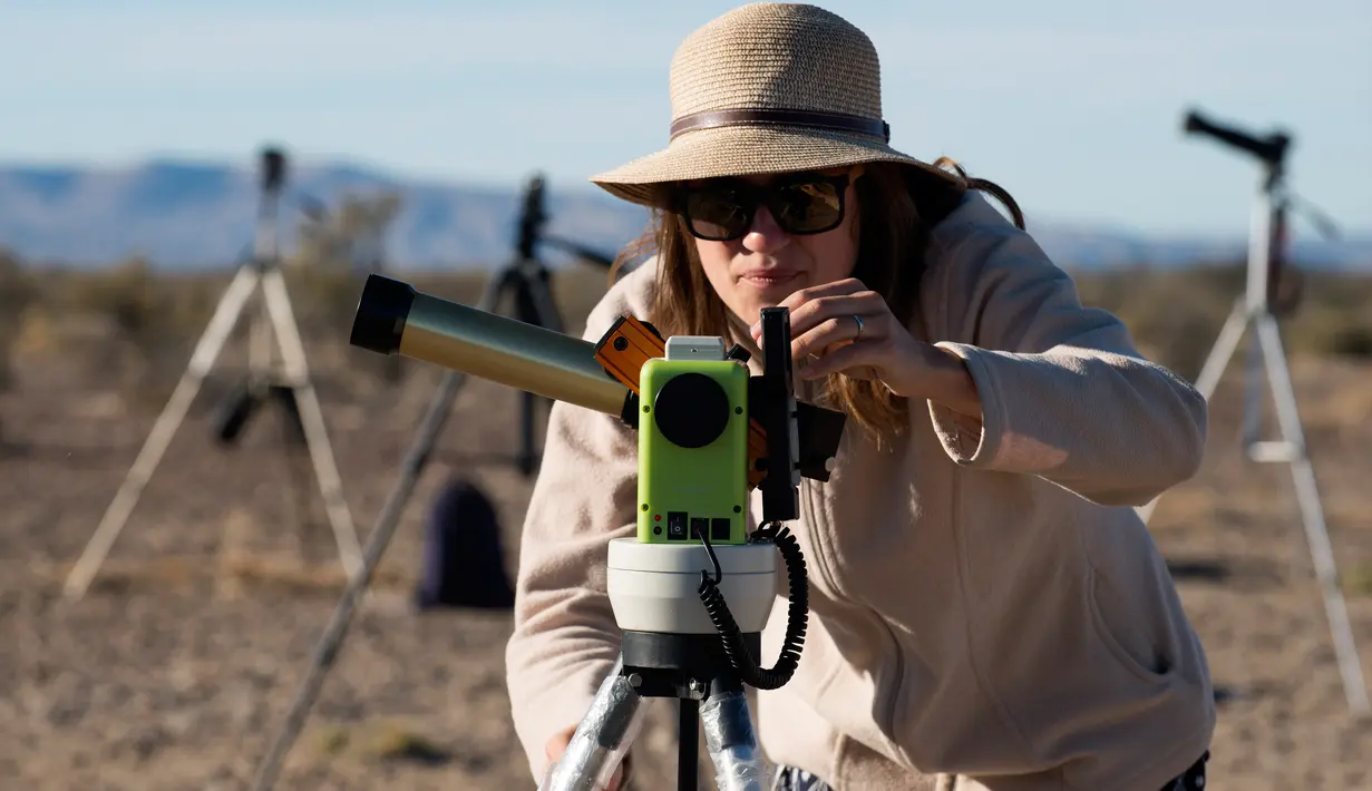Seorang wanita menggunakan alat khusus bersiap untuk melihat gerhana matahari annular di Estancia El Muster, Argentina (26/2). Para astronom dan penyuka astronomi di Argentina berkumpul untuk menyaksikan gerhana matahari annular. (AFP/Alejandro Pagni)