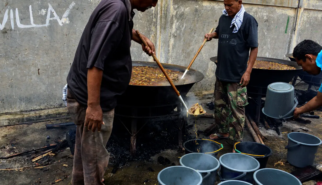 Orang-orang menyiapkan kari tradisional untuk disajikan dalam makanan komunal selama bulan suci Ramadhan di Banda Aceh (25/4/2021). Menu ini sering dimasak setiap memperingati kenduri Nuzul Quran pada setiap pertengahan bulan suci Ramadhan. (AFP/Chaideer Mahyuddin)