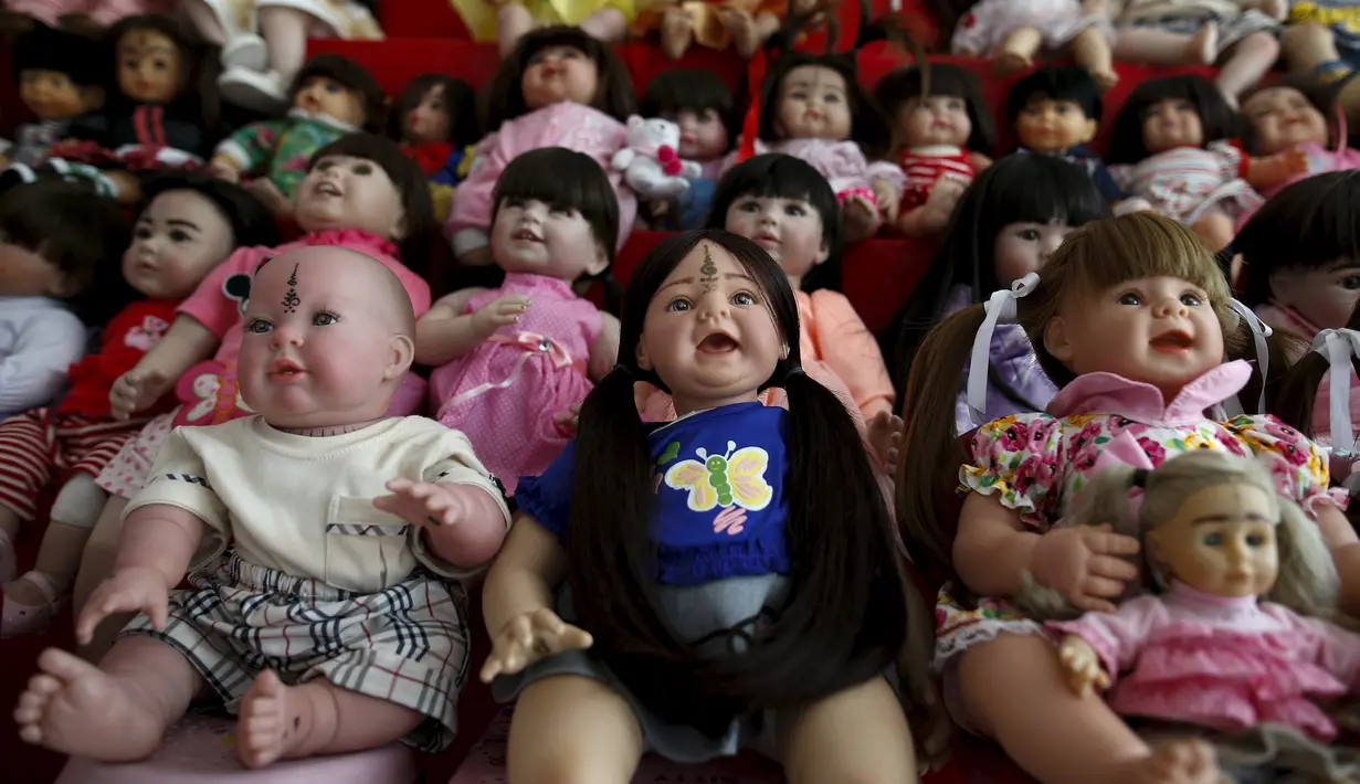 Boneka Look Thep (anak malaikat) di sebuah rumah yang menjual boneka di Bangkok, Selasa (26/1). Boneka yang diisi dengan roh anak kecil melalui ritual tertentu itu dipercaya warga Thailand bisa membawa keberuntungan (REUTERS/Athit Perawongmetha)