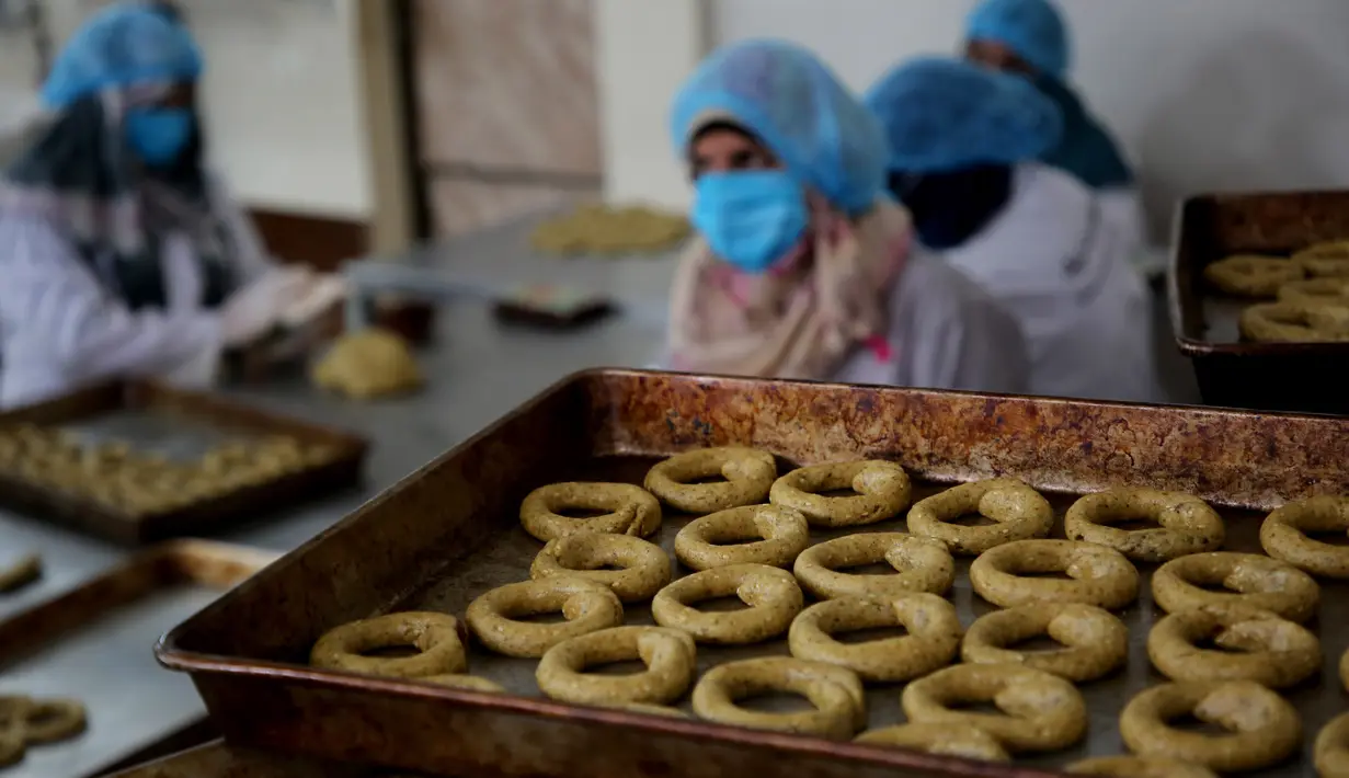Para perempuan Palestina menyiapkan kue tradisional untuk dijual di asosiasi wanita setempat menjelang Idul Fitri untuk merayakan akhir bulan suci Ramadan di tengah karantina wilayah (lockdown) akibat epidemi COVID-19 di Kota Beit Lahia, Jalur Gaza utara, pada 17 Mei 2020. (Xinhua/Rizek Abdeljawad)
