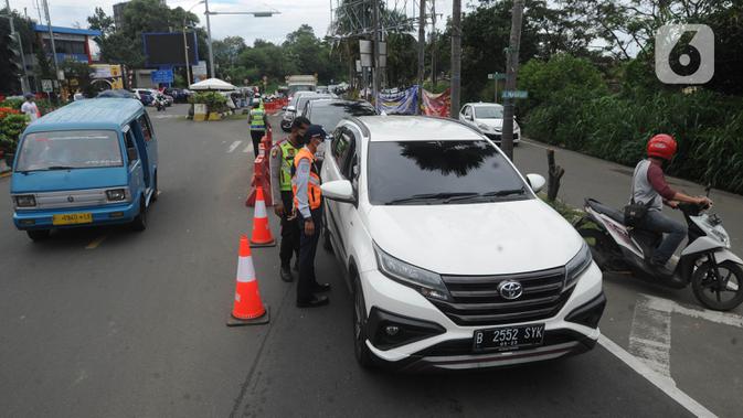 Petugas gabungan menghentikan pengendara mobil yang hendak menuju Puncak di Simpang Gadog, Bogor, Kamis (24/12/2020). Polisi bakal menutup jalur Puncak guna mengantisipasi lonjakan volume kendaraan dan penyebaran Covid-19 seiring peringatan malam tahun baru. (merdeka.com/Arie Basuki)