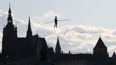 Aksi akrobat perempuan, Tatiana Mosio Bongonga, berjalan meniti tali melintas di atas sungai Vltava saat pembukaan Festival Sirkus dan Teater Internasional di Praha, Ceko, Rabu (14/8/2019). (Michal Cizek / AFP)