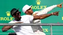 Pembalap Marcedes, Lewis Hamilton berpose dengan mantan atlet lari cepat asal Jamaika, Usain Bolt di atas podium setelah berhasil memenangi balapan GP Amerika Serikat di Circuit of Americas, Minggu (22/10). (CLIVE ROSE / GETTY IMAGES / AFP)