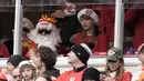 Taylor Swift (kanan) duduk di samping kakaknya, Austin yang berdandan ala Santa Klaus saat menyaksikan pertandingan NFL (National Football League) antara Kansas City Chiefs melawan Las Vegas Raiders di Arrowhead Stadium, Kansas, Amerika Serikat, Selasa (26/12/2023) WIB. (AP Photo/Charlie Riedel)