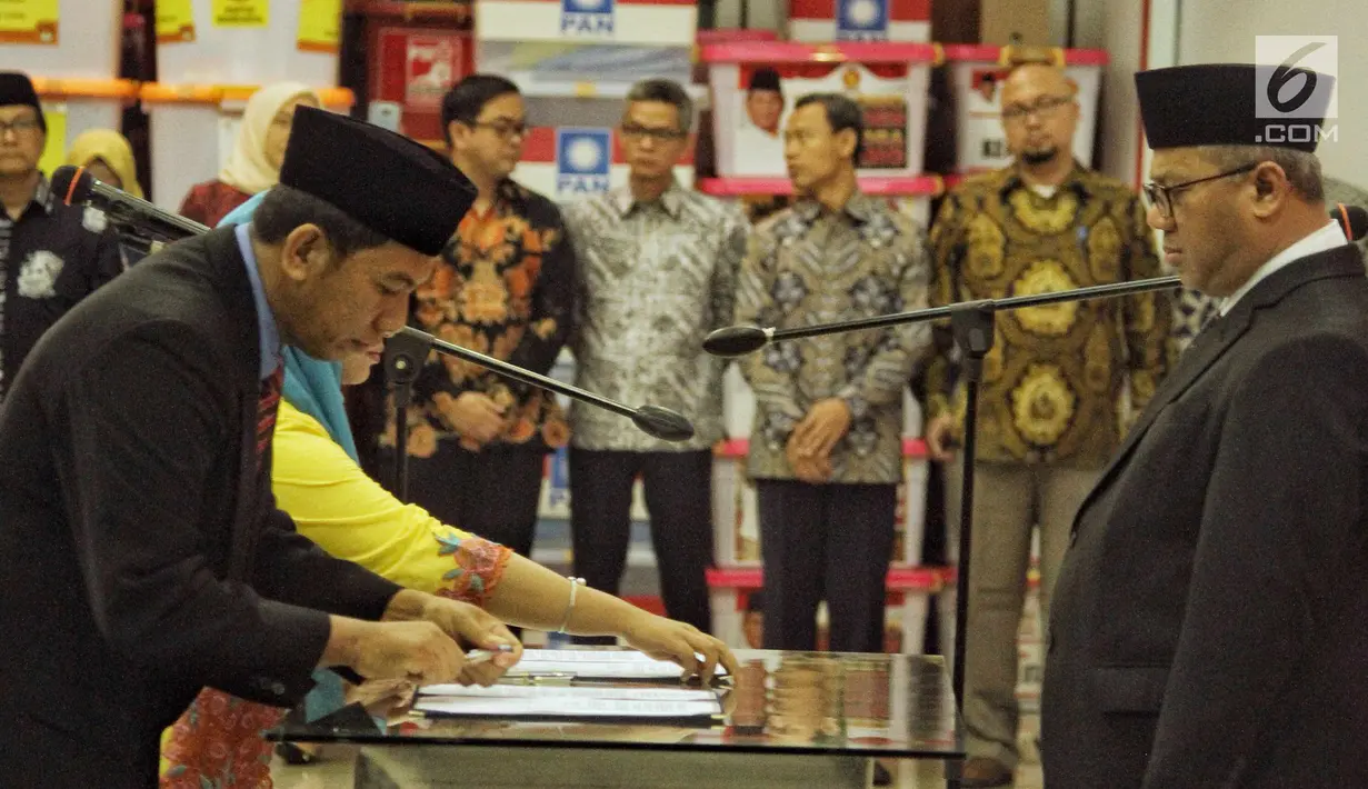 Ketua KPU Arief Budiman (kanan) menyaksikan penandatanganan saat pelantikan anggota KPU Kabupaten/Kota periode 2018-2023 di Gedung KPU RI, Jakarta, Minggu (24/6). (Liputan6.com/Faizal Fanani)