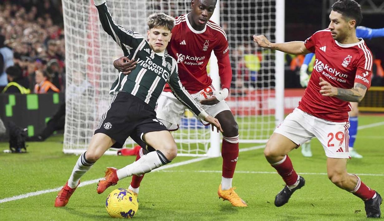 Pemain Manchester United, Alejandro Garnacho, dijaga ketat pemain Nottingham Forest, Moussa Niakhate dan Gonzalo Montiel pada laga pekan ke-20 Premier League 2023/2024, Minggu (31/12/2023) dini hari WIB. (AP Photo/Rui Vieira)
