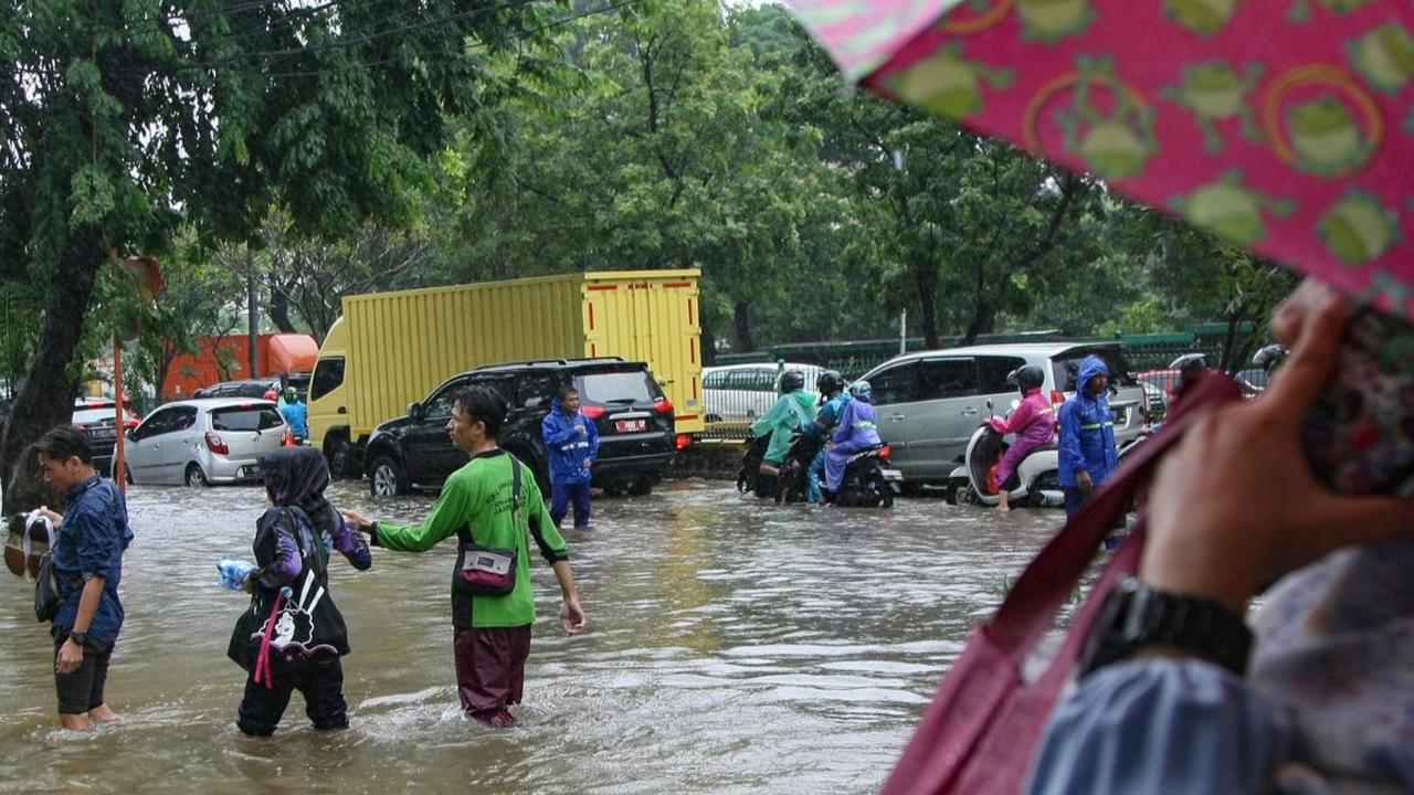 Sejumlah warga menerobos banjir yang menggenangi Jalan Suprapto, Cempaka Putih, Jakarta Pusat, Kamis (29/02/2024). Banjir parah ini terjadi setelah hujan lebat mengguyur Ibu Kota sejak Kamis dini hari. Merdeka.com/Arie Basuki