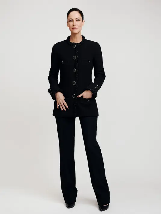 Anna Mouglalis tampil dengan aura refined sophistication lewat setelan hitam klasik khas Chanel. Ia mengenakan tailored jacket berstruktur dengan detail trimming tekstur di bagian tepian, dipadukan celana panjang berpotongan lurus yang memberikan kesan sleek dan powerful. [Dok/Chanel].