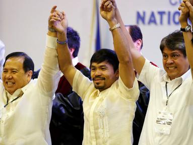 Manny Pacquiao bergandeng tangan bersama senator baru lainnya, Dick Gordon dan Kiko Pangilinan, Filipina, Kamis (19/5). Pacquiao berhasil menduduki 1 dari 12 kursi senator di Majelis Tinggi setelah mendapat 16 juta suara. (REUTERS/Erik De Castro)
