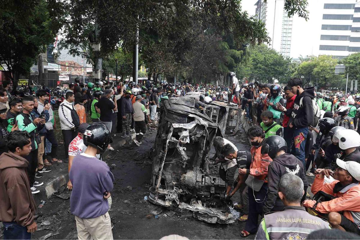 FOTO: Warga Ambil Bangkai Mobil Usai 10 Kendaraan Dibakar di Depan Mako Brimob Kwitang