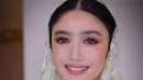 Riasan wajah yang natural dengan sentuhan soft glam dalam rona coral peach membuat Febby tampak segar dan elegan. [@upanduvan].