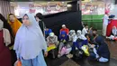 Sejumlah warga beristirahat usai berbelanja di pasar Tanah Abang, Jakarta, Minggu (26/5/2019). Jelang lebaran masyarakat mulai memadati pusat perbelanjaan untuk membeli kebutuhan saat Hari Raya Idul Fitri. (Liputan6.com/Angga Yuniar)