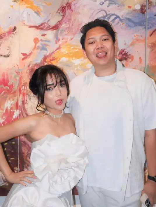 Disempurnakan dengan pulasan makeup flawless dan tatanan bun hairstyle with bangs yang begitu khas. [@fuji_an/@rachelvennya].