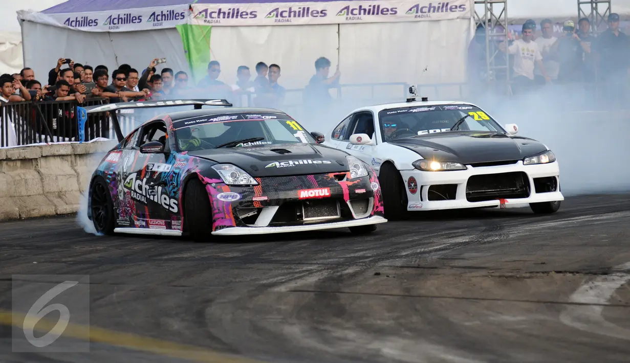 Dua drifter beraksi di ajang Achilles Motorsport Festival 2015 di JIExpo Kemayoran Jakarta, Sabtu (19/12). Achilles Motorsport Festival 2015 digelar di tiga kota, Jogjakarta, Surabaya, dan Jakarta. (Liputan6.com/Helmi Fithriansyah)