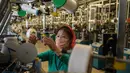 Seorang pekerja wanita mengecek benang saat berada di jalur produksi yang membuat kaus kaki pria di Pabrik Kaus Kaki Pyongyang di Korea Utara (24/5/2021). Pabrik ini memproduksi kaus kaki dengan menggunakan benang rayon Tetron domestik dan serat. (AFP/Kim Won Jin)