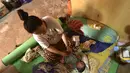 Armila merawat bayi laki-lakinya yang berusia sehari, Muhammad Al Aksa, di tempat pengungsian sementara setelah gempa berkekuatan 6,2 skala Richter mengguncang kota Mamuju, Sulawesi, Selasa (19/1/2021). (AFP/Firdaus)