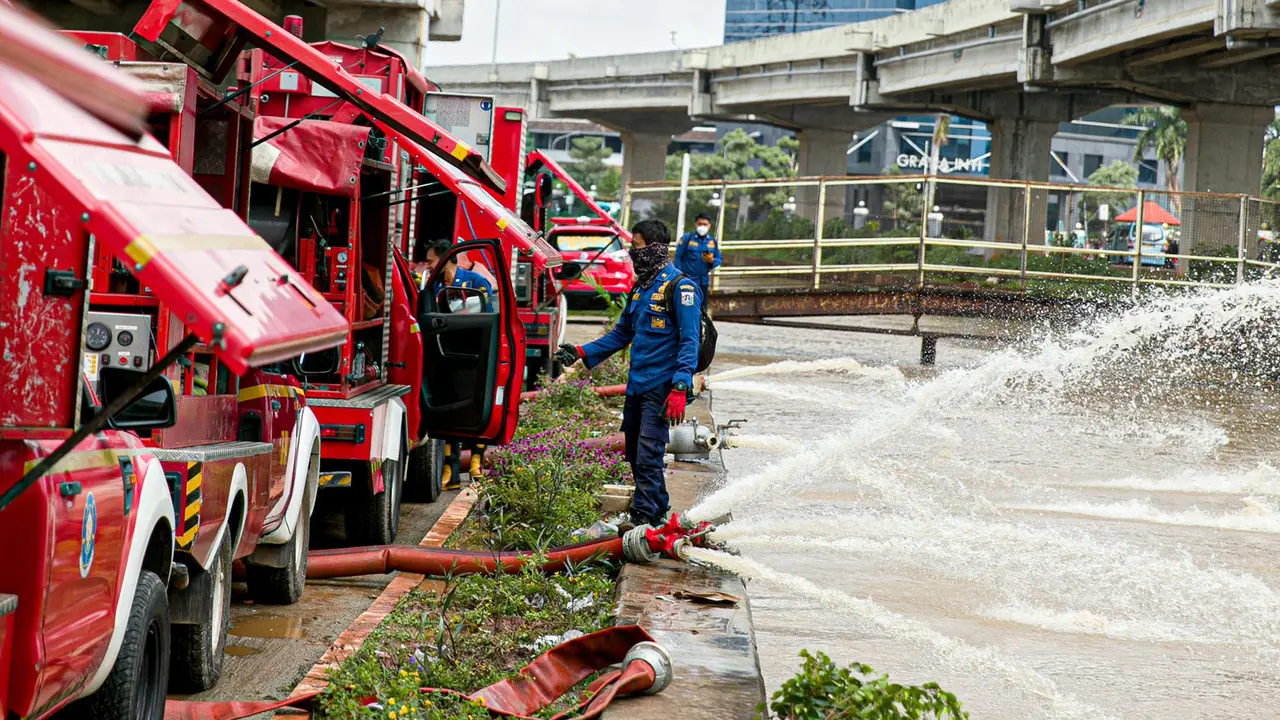 FOTO: Aksi Pemadam Kebakaran Sedot Air Banjir di Cipinang Melayu
