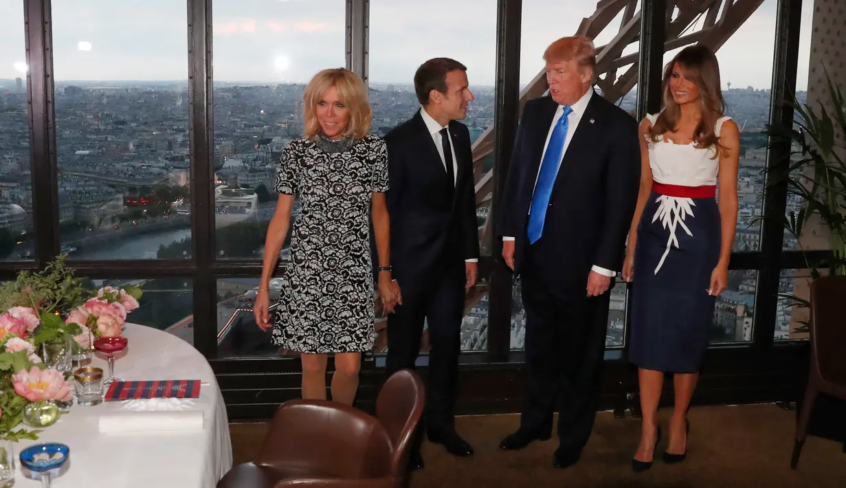 Presiden AS Donald Trump dan Melania Trump serta Presiden Prancis Emmanuel Macron dan Brigitte Macron bersiap untuk jamuan makan malam di Menara Eifel, Paris, Kamis (13/7). Kunjungan Trump ke Paris merupakan undangan Macron (Yves Herman/Pool Photo via AP)