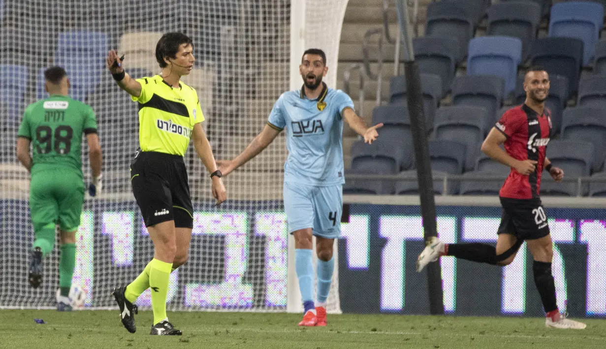 Wasit Sapir Berman memimpin pertandingan Liga Premier Israel antara Hapoel Haifa vs Beitar Jerusalem di kota Haifa, Senin (3/5/2021). Wasit sepak bola transgender pertama Israel turun ke lapangan untuk pertama kalinya sejak tampil di depan umum sebagai seorang wanita.  (AP Photo/Sebastian Scheiner)