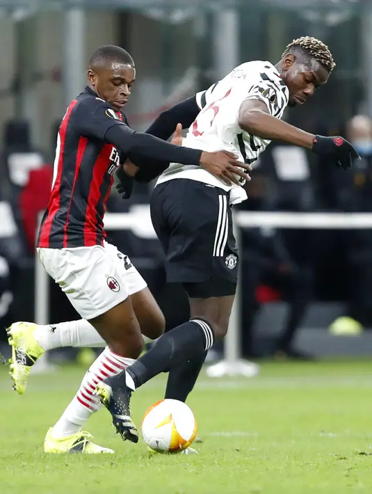 Pemain Manchester United Paul Pogba (kanan) dan pemain AC Milan Pierre Kalulu memperebutkan bola pada pertandingan leg kedua babak 16 besar Liga Europa di Stadion San Siro, Milan, Italia, Kamis (18/3/2021). Manchester United  menang 1-0. (AP Photo/Antonio Calanni)