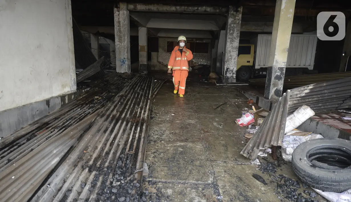 Petugas pemadam kebakaran melakukan pembasahan bioskop Grand Theater yang terbakar di Simpang Lima Senen, Jakarta, Jumat (9/10/2020). Unjuk rasa menentang disahkannya Omnibus Law UU Cipta Kerja berujung aksi anarkis merusak berbagai fasilitas umum pada Kamis malam (8/10). (merdeka.com/Dwi Narwoko)