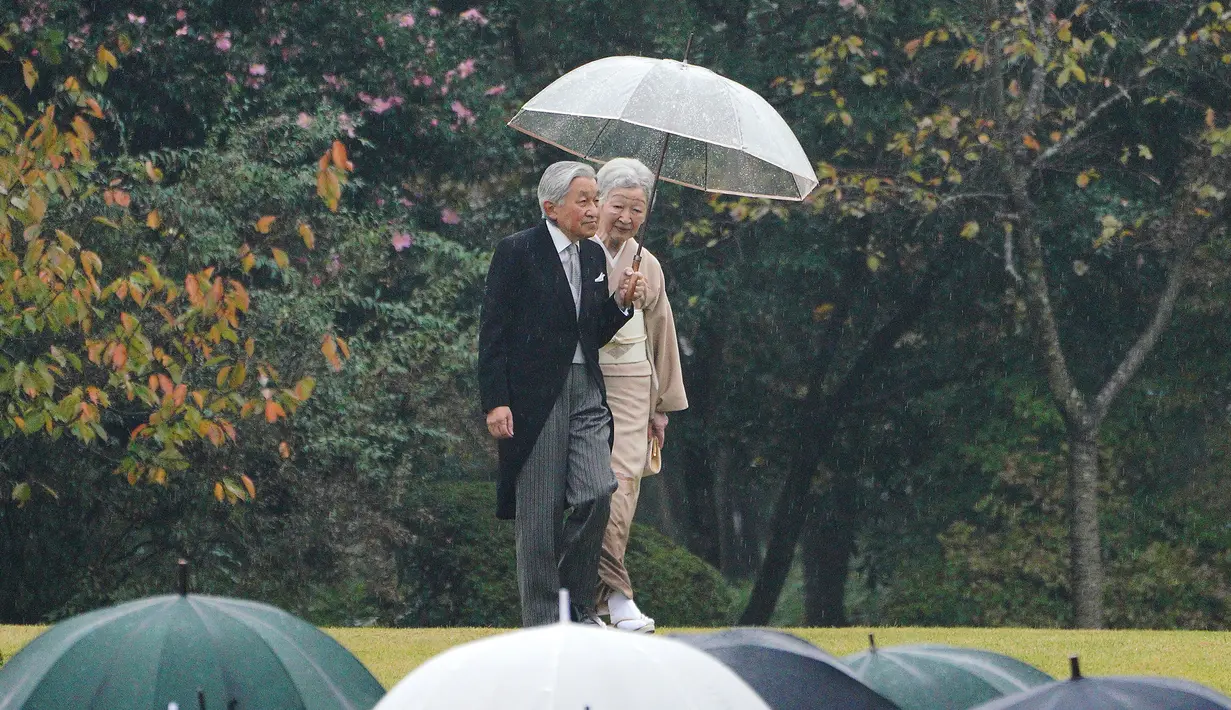 Kaisar Jepang Akihito dan Permaisuri Michiko berjalan menuruni bukit untuk menyambut tamu saat pesta taman musim gugur di taman kekaisaran Akasaka Palace, Tokyo, Jumat (9/11). (AP Photo/Eugene Hoshiko)