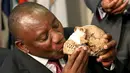 Wapres Afrika Selatan, Cyril Ramaphosa mencium replika tengkorak Homo Naledi, nenek moyang manusia yang baru ditemukan di Maropeng, Kamis (10 /9/2015). Ratusan potongan dari 15 kerangka ditemukan di satu gua di dekat Johannesburg. (REUTERS/Siphiwe Sibeko)