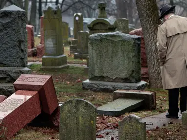  Warga melihat batu nisan Yahudi yang rusak usai serangan vandalisme di Chesed Shel Emeth Cemetery di University City, St Louis, Missouri, (21/2). Setidaknya lebih dari 100 batu nisan rusak di pekuburan itu. (Robert Cohen /St. Louis Post-Dispatch via AP)